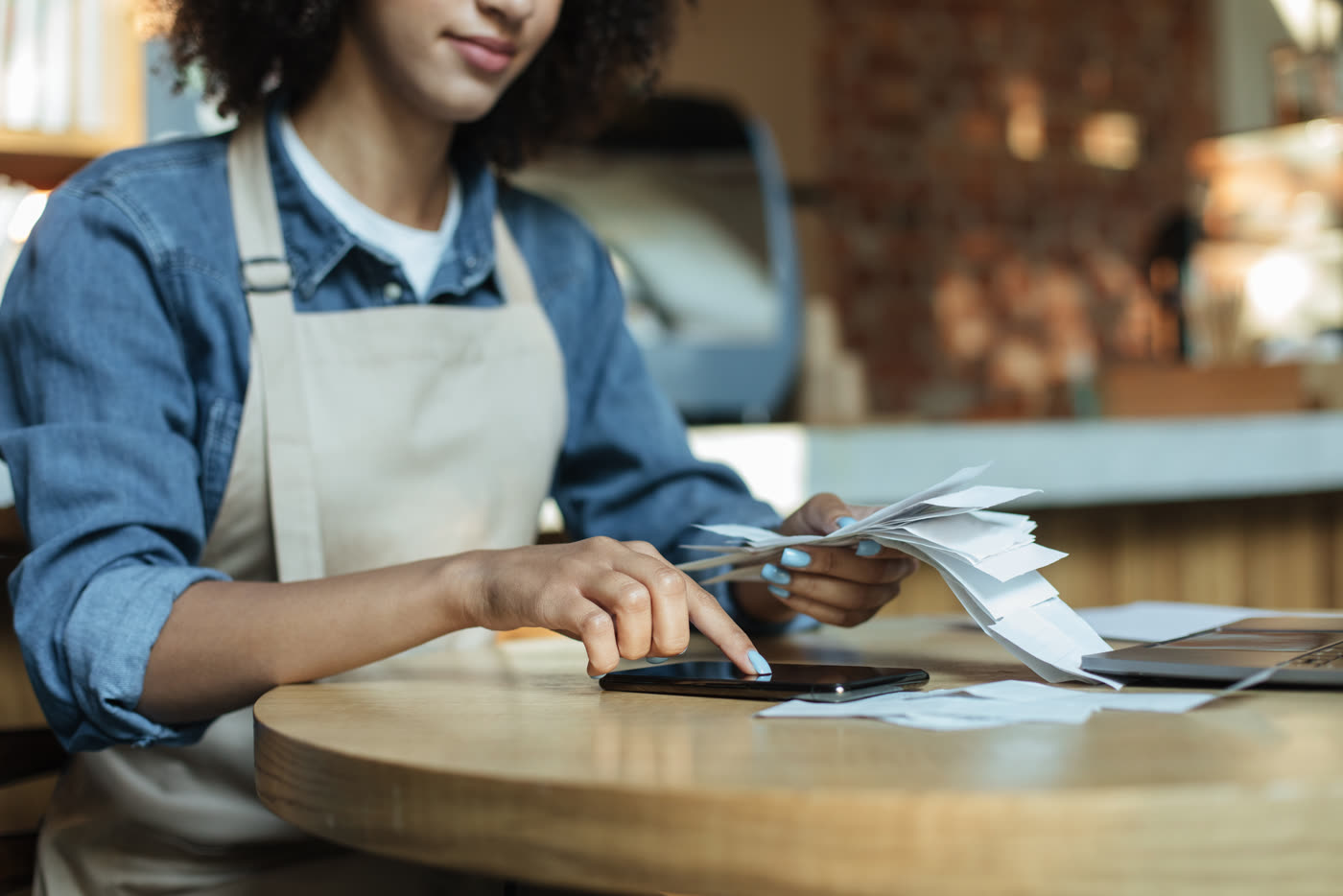 A cafe owner going through receipts at a table